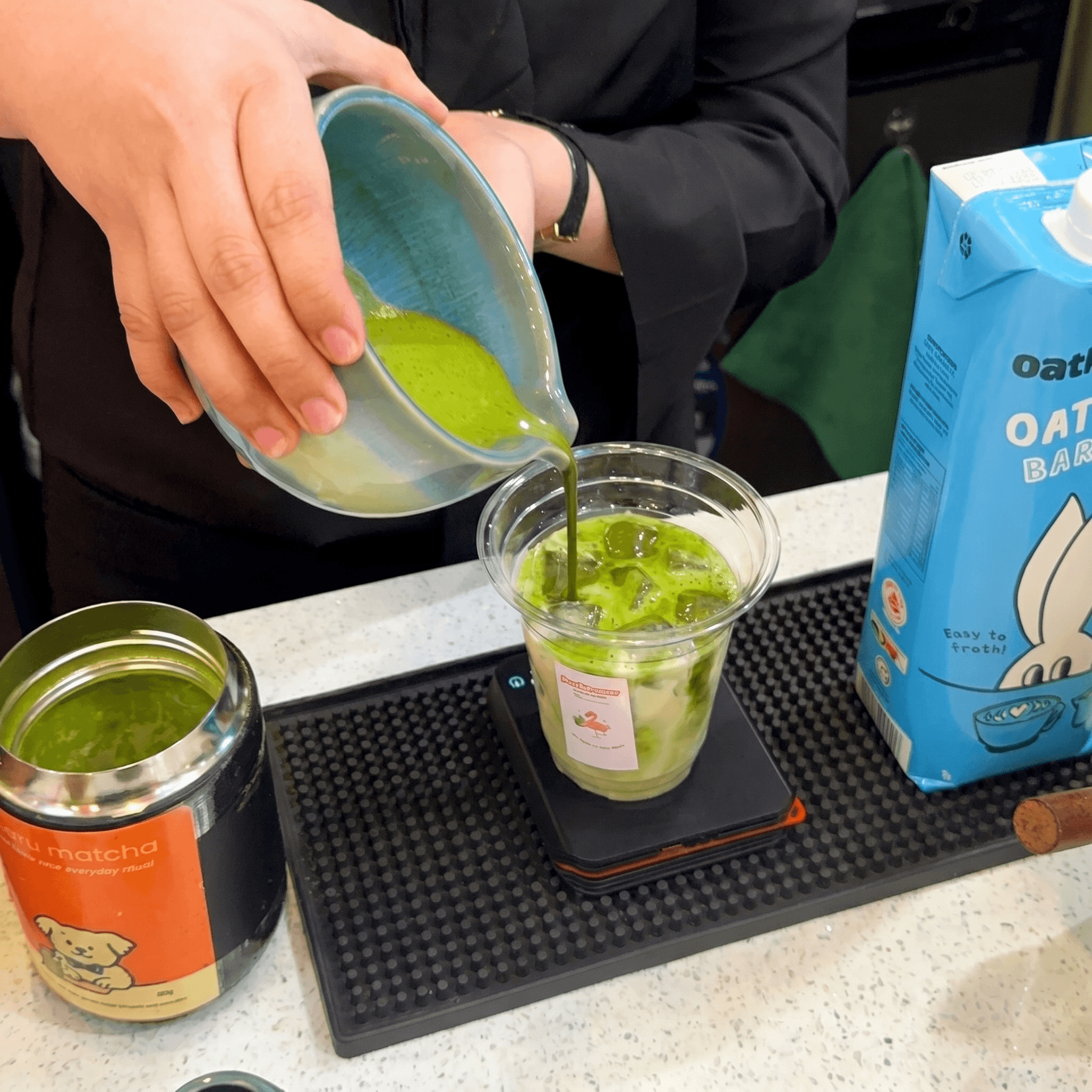 Matcha being hand-poured into an iced cup at the Dr. Brows Matcha Bar