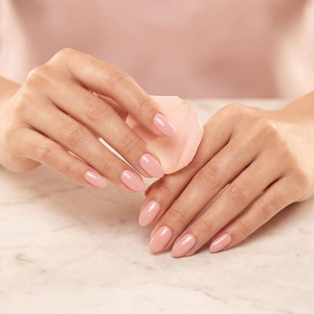 Blush pink almond-shaped nails resting on marble